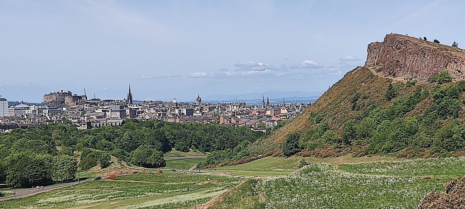 Panoramic view of Edinburgh Old Town from Arthur’s Seat, showing historic rooftops and cityscape.